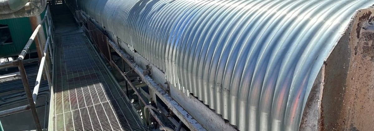 New galvanized CHCO Series corrugated conveyor belt covers installed on a conveyor at an industrial processing plant