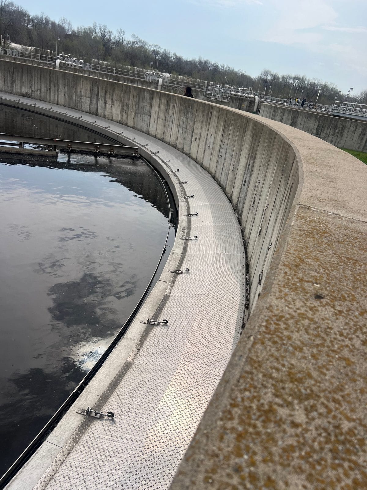 RPS Engineering aluminum diamond plate launder covers on a circular clarifier blocking sunlight to prevent algae on the weir and launder